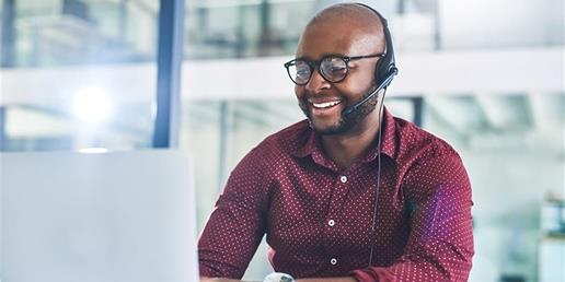 A person wearing a headset and using a computer